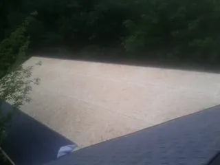 New OSB roof sheathing installed beside an existing shingle roof in Eagle